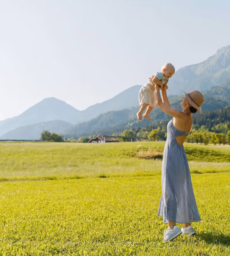 Parent holding a newborn baby close, forehead to forehead